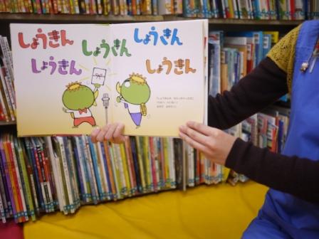 絵本を開いて見せている写真
